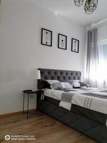 a bedroom with a large bed and a table at Apartman SATO in Brčko