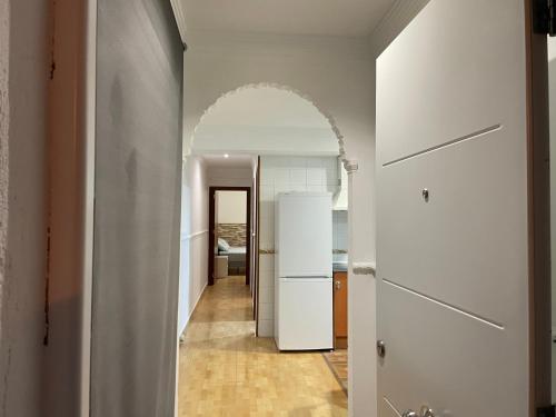 a hallway with a white refrigerator and an archway at Casa Oceano - 2 Bedroom Apartment in San Fernando