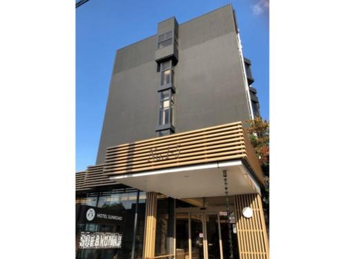 un edificio alto con una tienda delante de él en HOTEL SUNROAD - Vacation STAY 04184v, en Amakusa