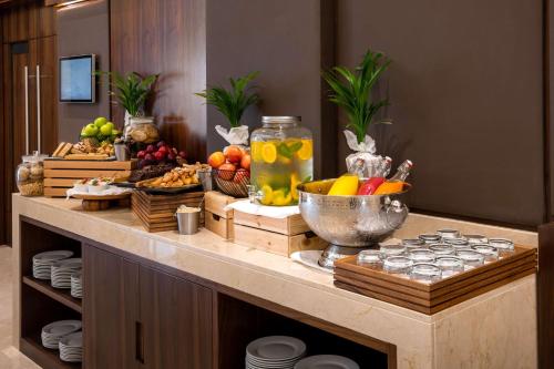 a buffet with fruit and drinks on a table at Radisson Resort Ras Al Khaimah Marjan Island in Ras al Khaimah
