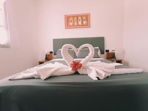 a bed with a heart made out of towels at Vilas na areia aparthotel in Sal Rei