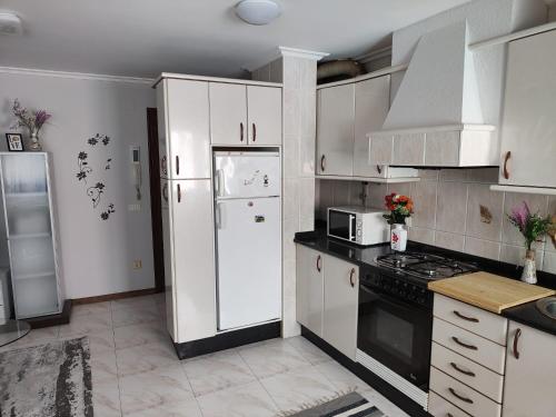 a kitchen with white cabinets and a white refrigerator at El nido de lu in Vilagarcia de Arousa