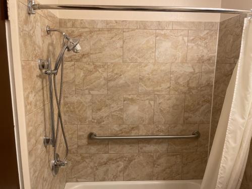 a shower in a bathroom with a shower curtain at Village Inn Green Bay in Green Bay