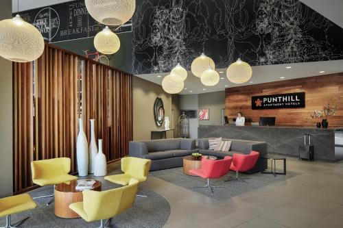 a lobby with a couch and colorful chairs at Punthill Norwest in Baulkham Hills