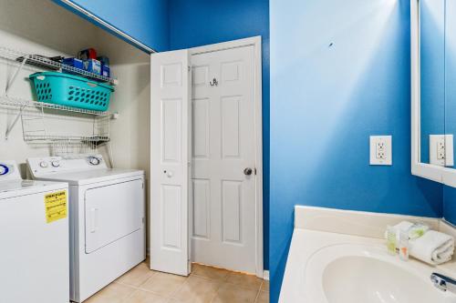 a bathroom with a sink and a washing machine at Coral Reef Retreat in Sunset Beach