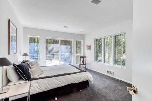 um quarto branco com uma cama grande e janelas em Black Butte Contemporary em Black Butte Ranch