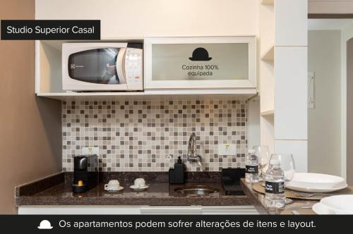 a kitchen with a sink and a microwave at NewCiti Itaim by Charlie in Sao Paulo
