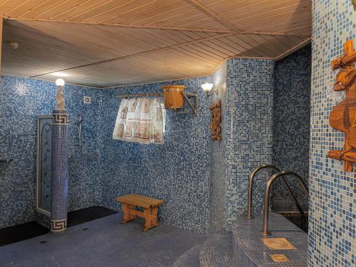 baño con paredes de azulejos azules y banco en Hotel Gloria Standard, en Burabay