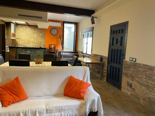 a living room with a white couch with orange pillows at Casa Rural La Sureña in Ossa de Montiel