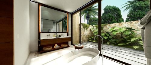Four Seasons Resort Tamarindo, México في Cihuatlán: حمام مع حوض استحمام و نافذة كبيرة