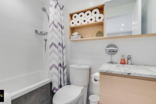 La salle de bains est pourvue de toilettes, d'un lavabo et d'une douche. dans l'établissement Songhees Breeze, à Victoria