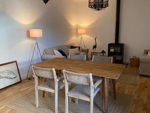 ein Wohnzimmer mit einem Holztisch und Stühlen in der Unterkunft Luz Los Romeros in Los Romeros