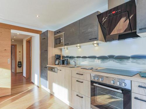 a kitchen with stainless steel appliances and wooden cabinets at Krammer Großvenediger in Neukirchen am Großvenediger