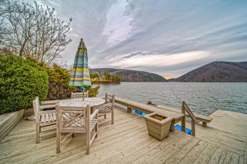 a wooden dock with a table and an umbrella on the water at Our Point of View in Huddleston