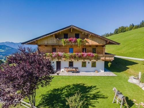 una casa en una colina con flores delante en Igl Hof Top 1, en Westendorf