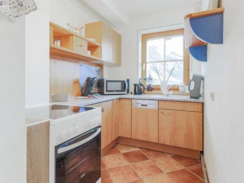 a small kitchen with wooden cabinets and a window at Igl Hof Top 3 in Westendorf
