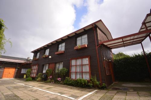 a black house with red doors and windows at Hotel Di Torlaschi in Valdivia