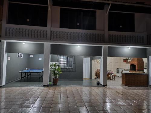 a living room with a ping pong table in a building at Casa grande e confortável até 16 pessoas com churrasqueira e garagem para 8 carros in Praia Grande