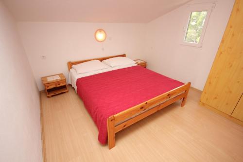 ein Schlafzimmer mit einem großen Bett mit einer roten Decke in der Unterkunft Apartments with a parking space Zavala, Hvar - 8912 in Zavala