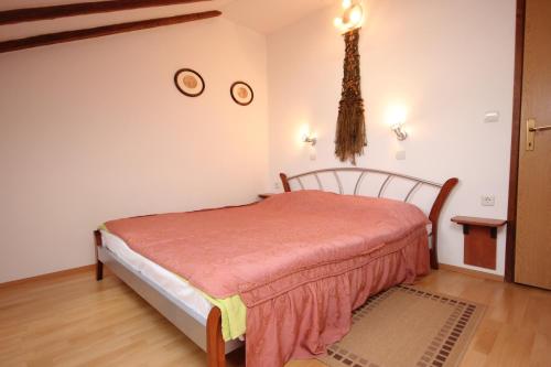 1 dormitorio con 1 cama y 2 relojes en la pared en Apartments by the sea Komiza, Vis - 8533, en Komiža