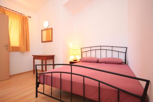 ein Schlafzimmer mit einem Bett mit einer roten Decke in der Unterkunft Apartments by the sea Ilovik, Losinj - 8069 in Ilovik