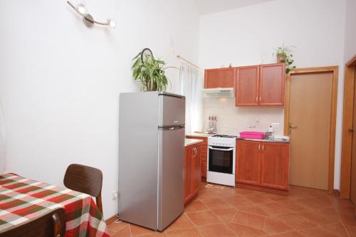 eine Küche mit einem Kühlschrank und einem Tisch darin in der Unterkunft Apartments by the sea Ilovik, Losinj - 8069 in Ilovik