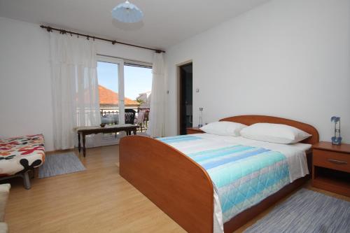 a bedroom with a bed and a balcony at Rooms by the sea Pasman - 8223 in Pašman