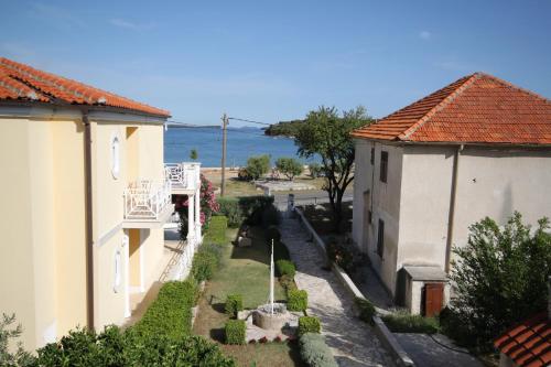 an alley between two buildings with the ocean in the background at Triple Room Pasman 8223a in Pašman