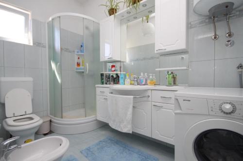 een witte badkamer met een toilet en een wastafel bij Apartments with a parking space Ugljan - 8404 in Ugljan