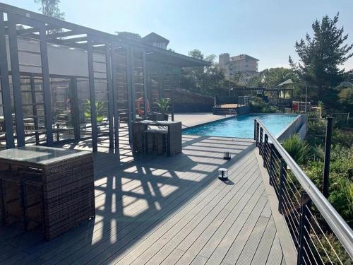 a deck with a swimming pool and a building at Departamento Nuevo Papudo - Full equipado - 7 personas in Papudo