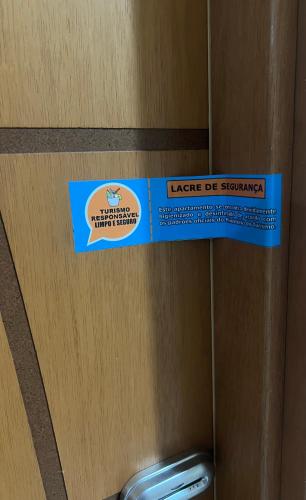 a sign on a wooden door in a bathroom at Loft 319 - INCOMPARÁVEL in Itacuruçá