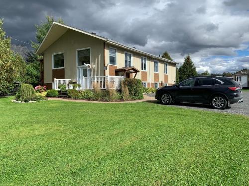 um carro preto estacionado em frente a uma casa em Aux quatre vents 3,5 logement intime et privé em Lac-Mégantic