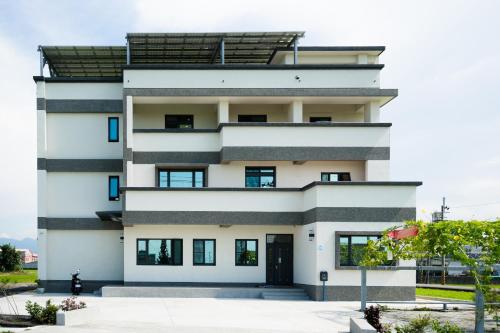 a large white building with black windows at Chin-Lan B&B in Zhuangwei