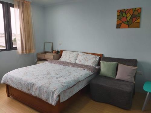 a bedroom with a bed and a couch at Chin-Lan B&B in Zhuangwei
