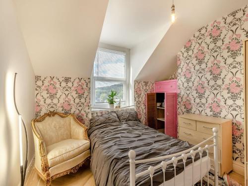 um quarto com uma cama e uma cadeira em 6 Fairfield Road em Buxton