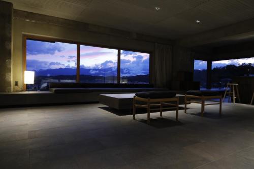 a room with two chairs and a table and windows at Matsumoto Jujo in Matsumoto