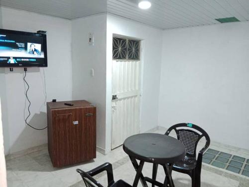 Habitación con mesa, sillas y TV. en Hermoso apartamento independiente para pareja, en Villavicencio