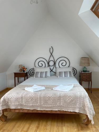 a bedroom with a large bed with a metal headboard at TY Fine Rose in Riec-sur-Bélon