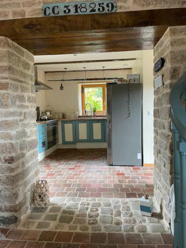 une cuisine avec des placards bleus et un mur en pierre dans l'établissement TY Fine Rose, à Riec-sur-Bélon