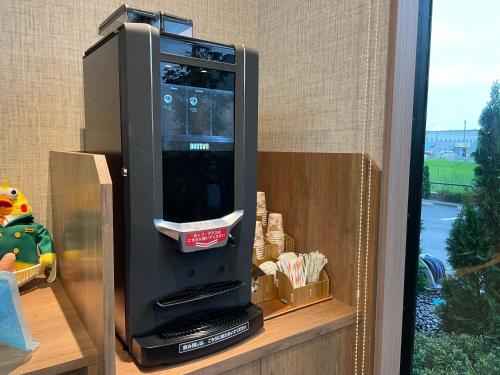 a black vending machine sitting on a shelf at Hotel Route Inn Mitsuke -Nakanoshima Mitsuke Inter- in Mitsuke