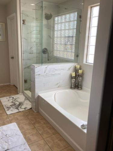 a white bathroom with a tub and a glass shower at Luxury in Laveen in Phoenix