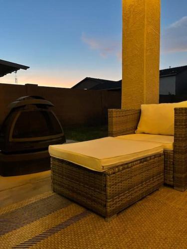a wicker couch sitting on a patio with a tv at Luxury in Laveen in Phoenix
