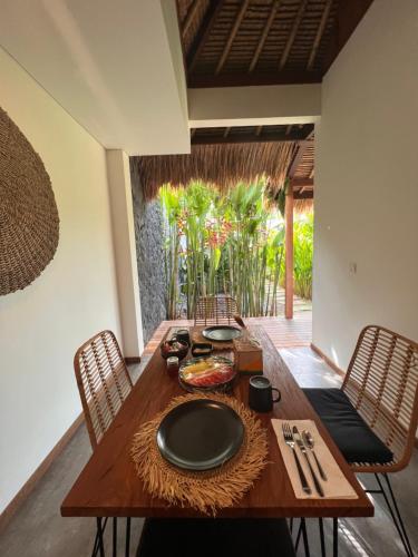 a wooden table with a plate on top of it at La Reserva Villas Bali in Jimbaran