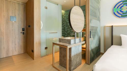 a bedroom with a bed and a mirror on a counter at Holiday Inn Resort Samui Bophut Beach by IHG in Bophut 