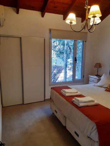 a bedroom with a bed and a large window at Cabañas Antares in Mar de las Pampas