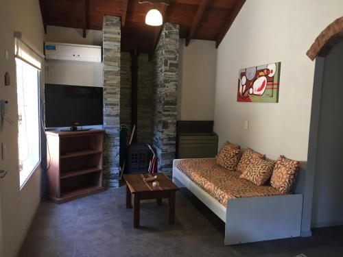 a living room with a couch and a flat screen tv at Cabañas Antares in Mar de las Pampas