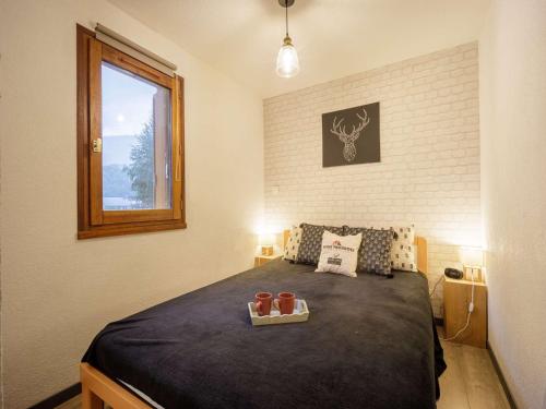 une chambre avec un lit avec un plateau dessus dans l'établissement Appartement pour 6 à 2 pas des remontées ! - FR-1-296-434, à Saint-Lary-Soulan