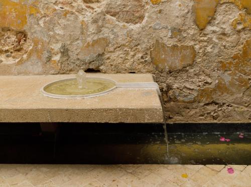 a water fountain in front of a stone wall at Las Lupitas Hotel Boutique in Campeche