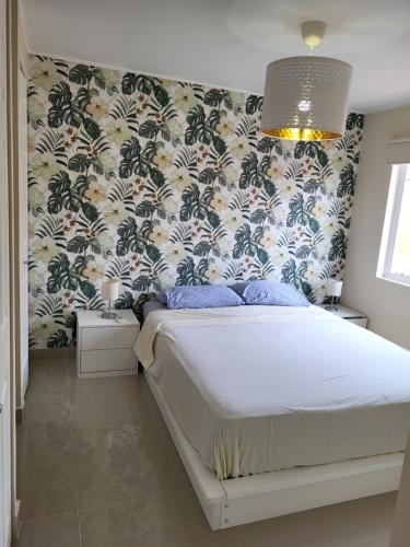 1 dormitorio con 1 cama y papel pintado con motivos florales en New 3 bedroom home in modern housing complex, en Manta
