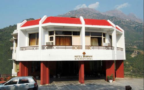 un bâtiment avec une voiture garée devant lui dans l'établissement Hotel Bhawani International, à Katra